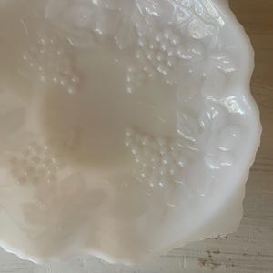 以下が含まれることがあります： 波打つ縁取りとブドウの模様が施された白いミルクガラスのボウル