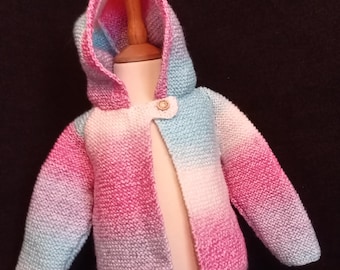 May include: A pink, blue, and white ombre knitted baby cardigan with a hood. The cardigan has a single button closure.