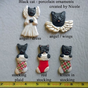 May include: Porcelain black cat ornaments. The ornaments include a black cat angel in a white dress, a black cat angel with wings, and black cats in Christmas stockings. The stockings are red and plaid.