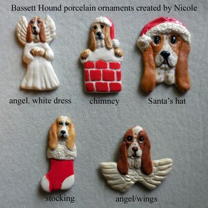 May include: A collection of Bassett Hound porcelain ornaments. The ornaments include a dog dressed as an angel, in a chimney, wearing a Santa hat, in a stocking, and with angel wings. The text "Bassett Hound porcelain ornaments created by Nicole" is at the top.