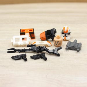 May include: A set of three ceramic mugs with a speckled, matte finish. Each mug features a different color: light blue, cream, and gray. The mugs have a simple, modern design and a comfortable handle.