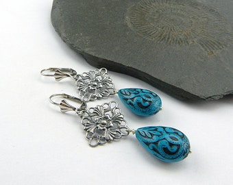Filigree silver, bright turquoise. Long drop earrings with delicately decorated drops in turquoise blue and black. Winter jewelry.