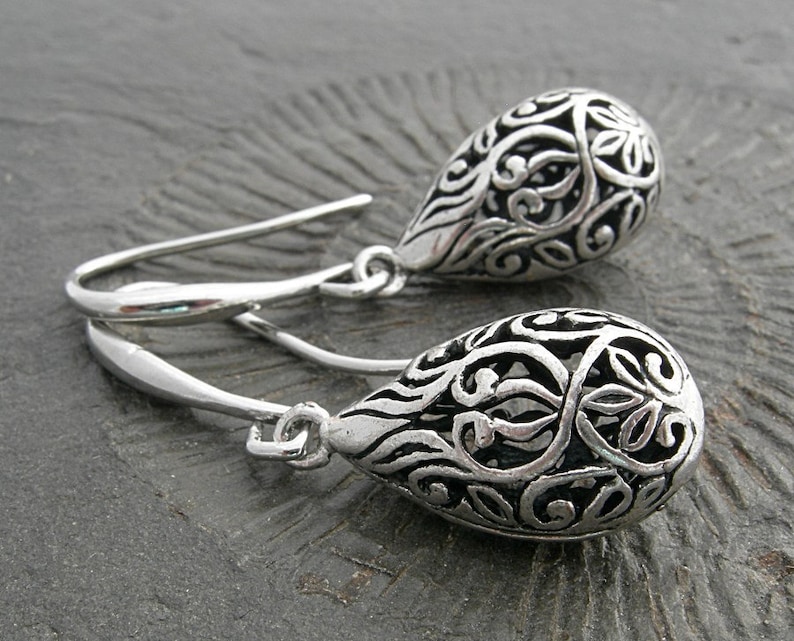 Filigree hollow silver plated drops on beautifully curved and oblong earwires. Feminine and delicate earrings. image 2