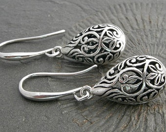 Filigree hollow silver plated drops on beautifully curved and oblong earwires. Feminine and delicate earrings.