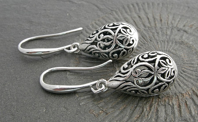 Filigree hollow silver plated drops on beautifully curved and oblong earwires. Feminine and delicate earrings. image 1