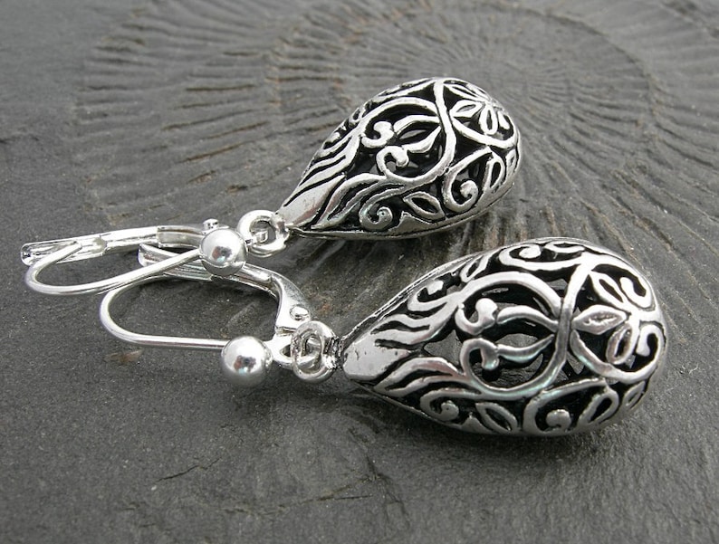 Filigree hollow silver plated drops on beautifully curved and oblong earwires. Feminine and delicate earrings. image 5