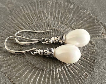 Pearl Drop Earrings. Shimmering white shell drop beads on oblong earwires and ornated bead cap. Elegant and feminine classic earrings.