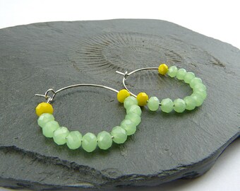 Cristaux de verre vert pastel doux et jaune opaque brillant. Boucles d'oreilles créoles colorées en laiton plaqué argent. De minuscules perles de verre scintillantes sur des cerceaux.