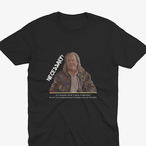 May include: A black t-shirt with a white graphic of a man with long hair and a beard. The graphic includes the text "NECESSARY?" and "IS IT NECESSARY FOR ME TO DRINK MY OWN URINE? NO, BUT I DO IT ANYWAY BECAUSE IT'S STERILE AND I LIKE THE TASTE."