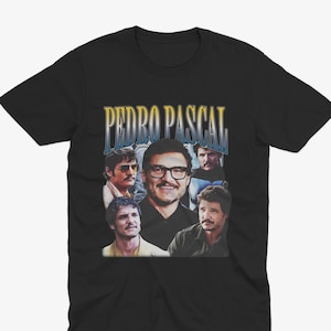 May include: Black t-shirt with a collage of images of Pedro Pascal and the text "PEDRO PASCAL" in a retro font. The images show Pascal in different poses. The shirt is made of a soft material and is suitable for casual wear.