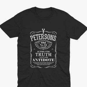 May include: Black t-shirt with a white graphic of a vintage label for "Petersons Old No. 12 Lobster" with the text "Authentic Truth Anti SJW Antidote Distilled and Aged by 330 Million Years of Evolution Without Equality of Outcome."