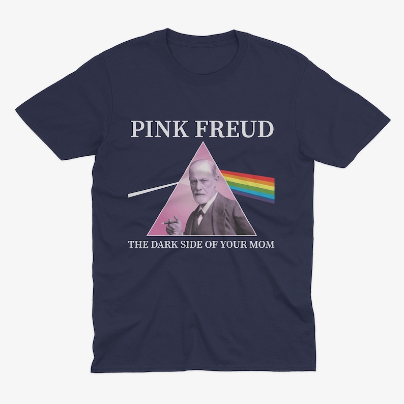May include: Navy blue t-shirt with a pink triangle and a picture of Sigmund Freud. The text "PINK FREUD" is above the triangle and the text "THE DARK SIDE OF YOUR MOM" is below the triangle.