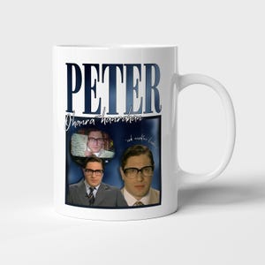 以下が含まれることがあります： 白いセラミックマグカップ。マグカップには、濃い青色の文字で「PETER」と書かれています。その下には筆記体で「Ohana hamraham」と書かれています。マグカップには、メガネをかけた男性の3つの画像と「ich nichte liebe...」というフレーズが表示されています。