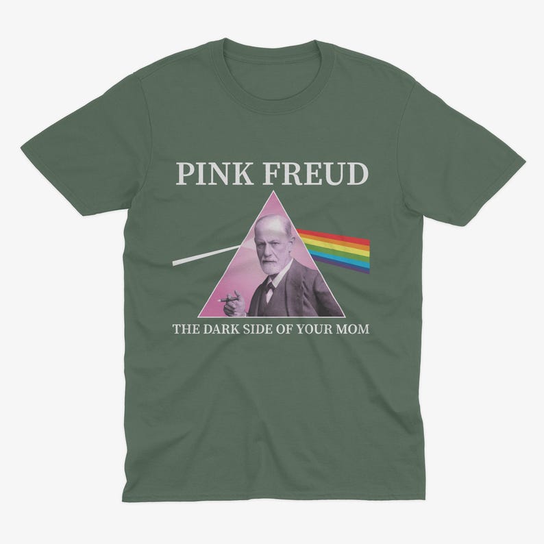 May include: A green t-shirt with a pink triangle and the text "PINK FREUD" above a picture of Sigmund Freud with a cigarette in his hand. The text below the image reads "THE DARK SIDE OF YOUR MOM".