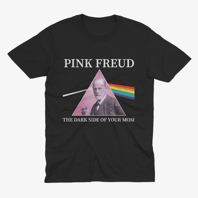 May include: Black t-shirt with a pink triangle and a picture of Sigmund Freud inside. The text "PINK FREUD" is above the triangle and "THE DARK SIDE OF YOUR MOM" is below the triangle.