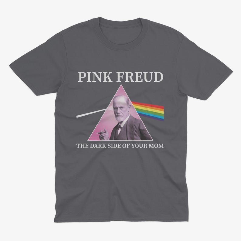 May include: Dark grey t-shirt with a pink triangle and a rainbow. The triangle features a picture of Sigmund Freud with a cigarette in his hand. The text "PINK FREUD" and "THE DARK SIDE OF YOUR MOM" are printed on the shirt.
