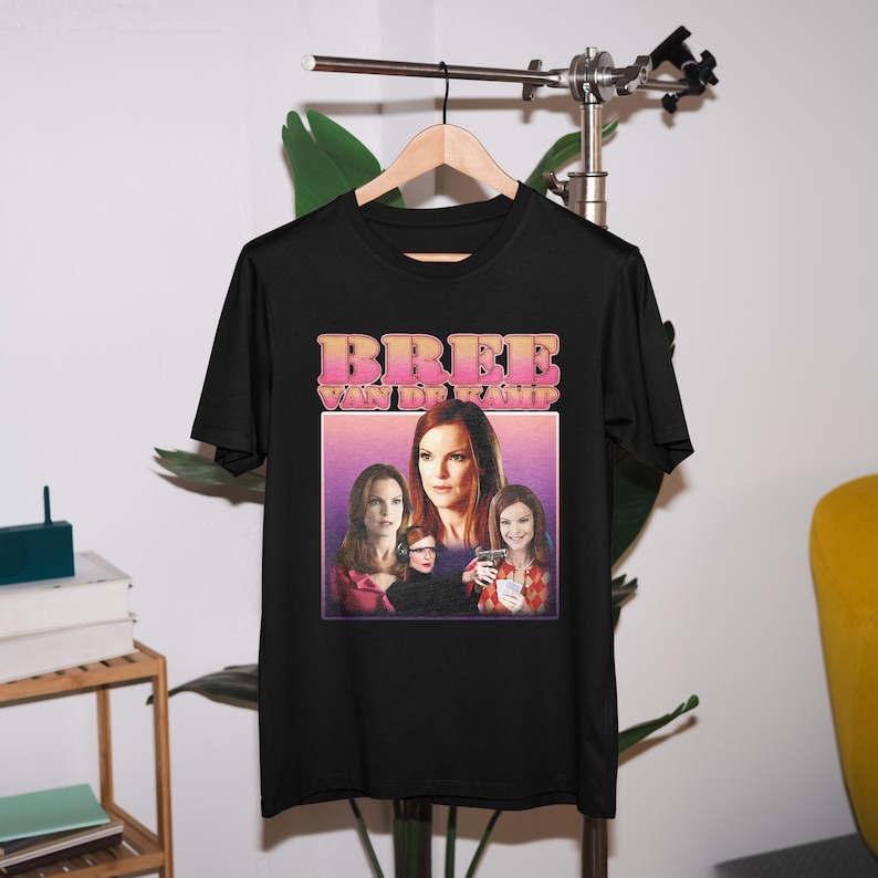 May include: Black t-shirt with a graphic print of Bree Van de Kamp from the TV show Desperate Housewives. The graphic features Bree and two other characters from the show.