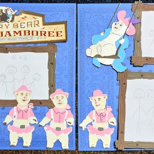 Puede incluir: Una página de álbum de recortes con un fondo azul y un marco de madera marrón. El marco tiene un papel blanco en el interior con un dibujo de una familia de osos. El texto "Country Bear Musical Jamboree" está en la parte superior de la página.