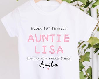 May include: A white short-sleeved t-shirt featuring the black text Happy 30th Birthday, pink text reading AUNTIE LISA, black text reading Love you to the moon & back, the name Amelia in black script, and a small pink heart icon below the name.