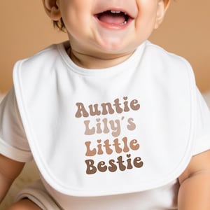 Cream-coloured baby bib featuring a retro "Auntie’s Little Bestie" message, ideal for a cute and practical gift from aunties.