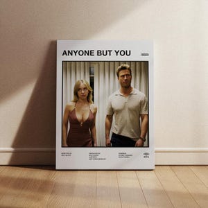 Può includere: Locandina del film "Anyone But You", uscito nel 2023. La locandina presenta Sydney Sweeney e Glen Powell, che guardano entrambi direttamente lo spettatore. La locandina è in stile minimalista con uno sfondo bianco e testo nero.