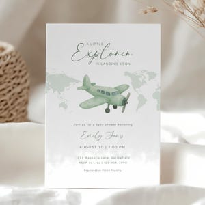 May include: Baby shower invitation with a watercolor illustration of a green airplane. The text reads "A Little Explorer is Landing Soon" and includes details for the event, including the name Emily Jones and the date.