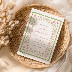 Puede incluir: Una invitación para un baby shower con el texto "Emily's Baby Shower" en escritura rosa. La invitación está enmarcada con un borde verde y adornos florales rosas. También se muestran la fecha y la hora, junto con la dirección y la información de RSVP.
