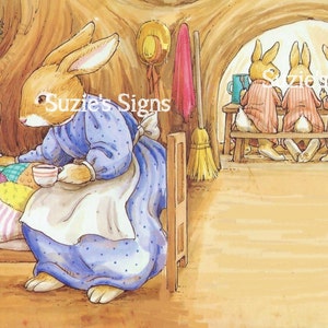 May include: An illustrated scene depicts a rabbit in bed being cared for by another rabbit. The caring rabbit is holding a cup. Other rabbits are seated on a bench in the background. The image has the text "Suzie's Signs".