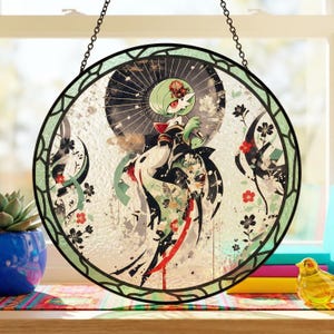 Może przedstawiać: Okrągłe witrażowe okno z postacią Gardevoir. Grafika zawiera zieloną, białą i czarną kolorystykę z kwiatowymi akcentami i czarnym łańcuchem do zawieszenia. Projekt jest osadzony na teksturowanym tle.