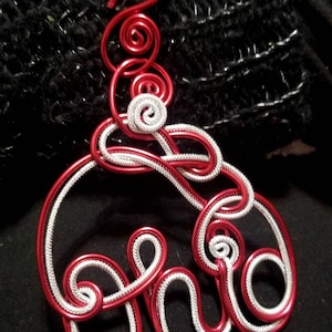 May include: A red and silver wire ornament shaped like the word "Ohio".