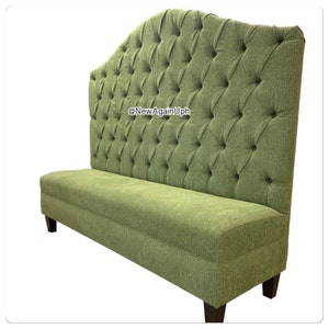 Op de afbeelding: Een groene, gestoffeerde bank met knopen en een gebogen rugleuning en houten poten. De bank heeft een knopenpatroon en is perfect voor een eetkamer of wachtruimte. @NewAgainUph