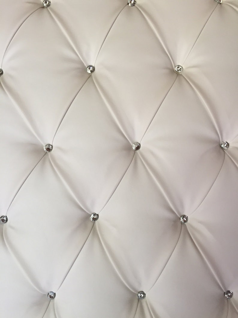 May include: White tufted upholstery with diamond-shaped tufting and clear crystal-like buttons.