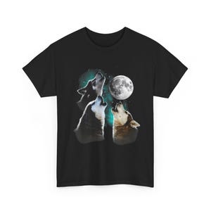 Op de afbeelding: Zwart t-shirt met een afbeelding van drie wolven die naar de volle maan huilen. De wolven zijn afgebeeld in grijstinten en bruin, met een achtergrond van een sterrenhemel. De maan is een helderwitte cirkel.