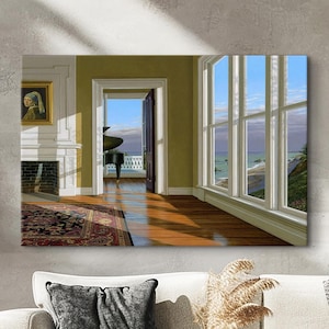 Op de afbeelding: Een ingelijste canvas print met een interieursc&egrave;ne met uitzicht op zee. De kamer heeft een open haard, een tapijt en een deuropening naar een balkon. Grote ramen bieden uitzicht op de zee en de lucht. De kamer is ingericht in neutrale tinten.