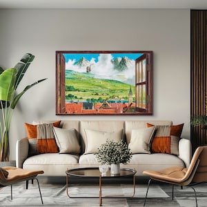 May include: A painting of a window view with a small town and mountains in the distance. The window is framed in wood and has a white background. The town is made up of small, colorful houses with red roofs. The mountains are covered in snow and are in the background of the painting.