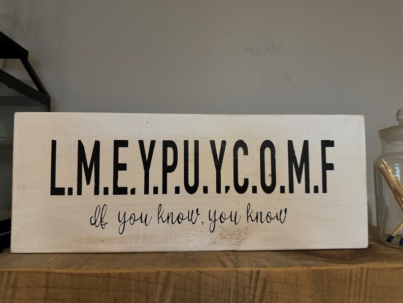 May include: White wooden sign with black lettering that reads "L.M.E.Y.P.U.Y.C.O.M.F. If you know, you know."