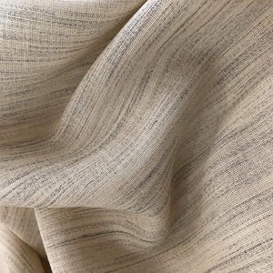 May include: Close-up of a beige fabric with a subtle woven texture. The fabric has a slightly textured, almost linen-like appearance.