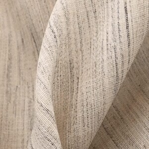 May include: Close-up of a beige fabric with a subtle woven texture. The fabric has a slightly rough, natural feel.
