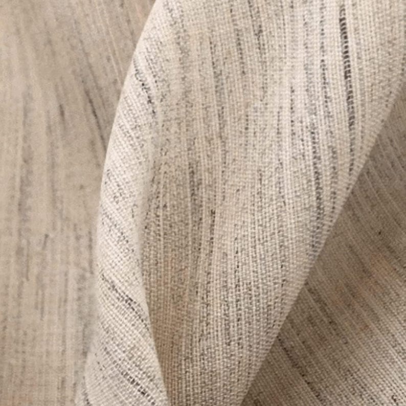 May include: Close-up of a beige fabric with a subtle woven texture. The fabric has a slightly rough, natural feel.