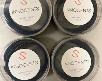 May include: Four clear plastic containers with black lids, each containing a roll of black waterproof zipper tape. The tape is labeled "S INNOCENTS waterproof zipper 31inch".