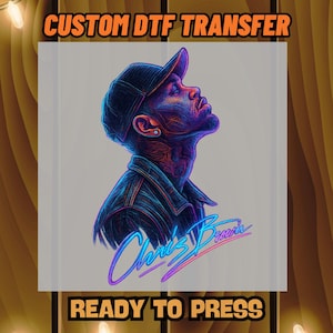 May include: A DTF transfer featuring a stylized portrait of Chris Brown in shades of blue and purple. The image includes the text "CUSTOM DTF TRANSFER" and "READY TO PRESS" in orange, with the artist's signature in neon blue and pink.