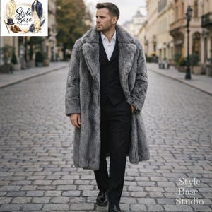 May include: A man in a long, grey faux fur coat, black suit, and white shirt, walking on a cobbled street. The coat has a wide lapel and is full length. The image includes the text "Style Base Studio".