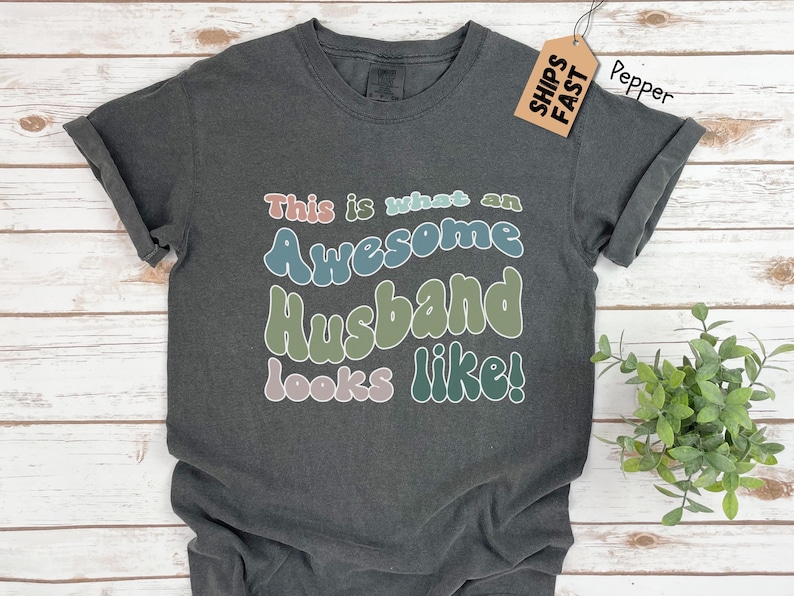 May include: White t-shirt with the text 'Python is my first language, English is my second.' in colorful, bubble-like letters.