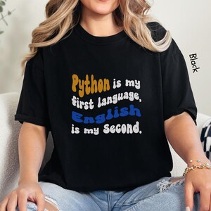 May include: Black t-shirt with the text "Python is my first language, English is my second."