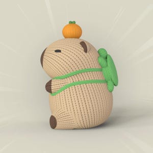 May include: A brown knitted capybara plush toy with a green backpack and an orange pumpkin on its head.