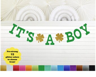 May include: Green and gold glitter banner that reads "IT'S *A* BOY" with shamrock accents. The banner is pre-strung and comes in 15 glitter colors.