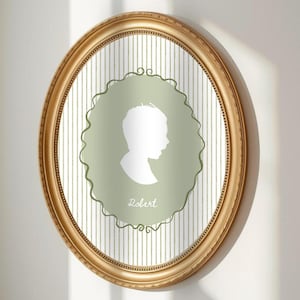 May include: An oval, gold-framed portrait featuring a white silhouette on a sage green background. The silhouette is of a person's profile, with the name "Robert" written below. The background has vertical white and light gray stripes.