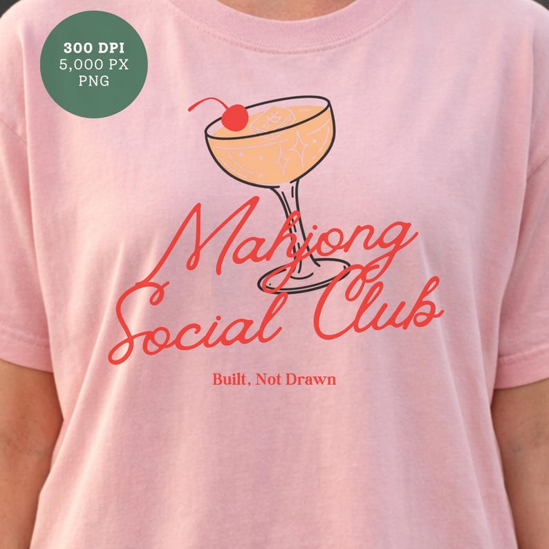 K&ouml;nnte beinhalten: Hellrosa T-Shirt mit Cocktail-Grafik und Kirsche. Der rote Schriftzug "Mahjong Social Club" ist in Schreibschrift gehalten, darunter "Built, Not Drawn". Das T-Shirt besteht aus weichem Stoff.