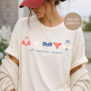 Peut inclure: T-shirt cr&egrave;me avec une rang&eacute;e d'illustrations de bikinis rouges, blancs et bleus. L'expression "all american summer" est imprim&eacute;e en bleu en dessous. Le t-shirt a des manches retrouss&eacute;es.