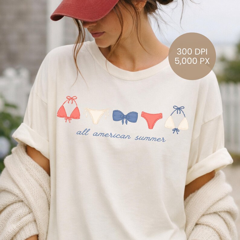 Peut inclure: T-shirt cr&egrave;me avec une rang&eacute;e d'illustrations de bikinis rouges, blancs et bleus. L'expression "all american summer" est imprim&eacute;e en bleu en dessous. Le t-shirt a des manches retrouss&eacute;es.